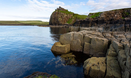 Rock formations by sea against sky