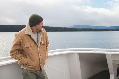 Man looking at lake against sky