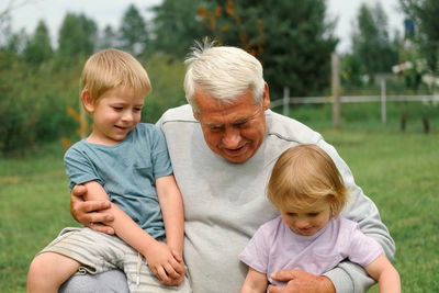 Portrait of smiling family sitting on field