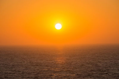 Scenic view of sea against orange sky