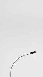 Close-up of black wire against white background