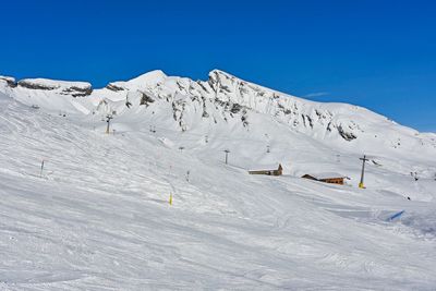 Scenic view of snowcapped mountains against blue sky