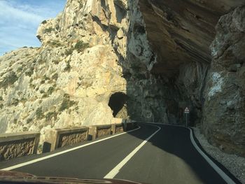 Man on mountain road against sky