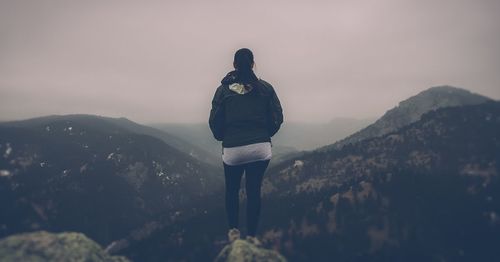 Rear view of woman standing on mountain