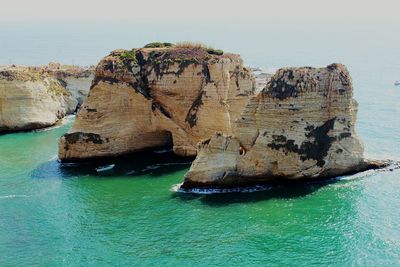 Rock formation in sea against sky