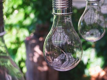 Close-up of light bulb hanging from glass