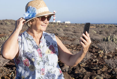 Portrait of woman photographing with mobile phone