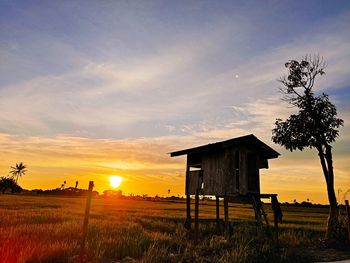 Built structure on field against sky during sunset