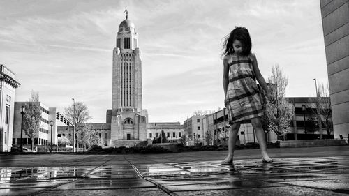 Girl standing against nebraska state capitol building 