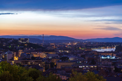 High angle view of illuminated city against sky at sunset