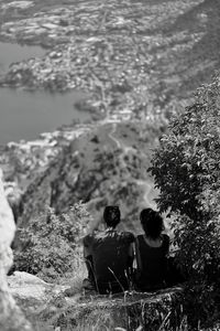 Rear view of couple sitting on water