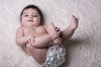 Portrait of cute baby lying on bed