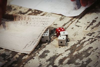 High angle view of dice by papers on wooden table