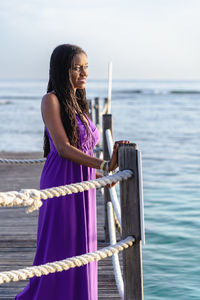 Portrait of young black woman standing against sea