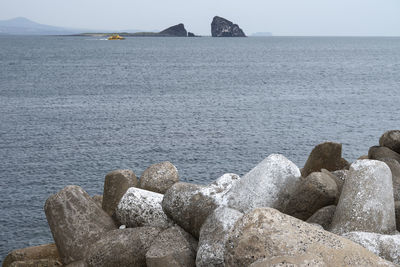 Rocks by sea against sky