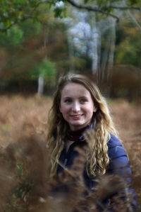 Portrait of smiling young woman in forest