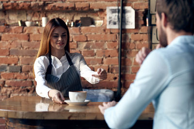 Waitress holding coffee cup at cafe