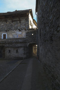 Footpath amidst buildings against sky