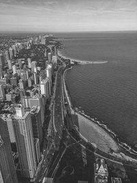 High angle view of sea by buildings against sky