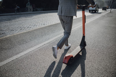 Businessman walking with e-scooter in the city
