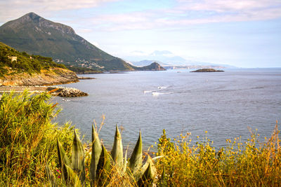 Scenic view of sea and mountains against sky