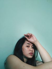 Portrait of young woman against wall