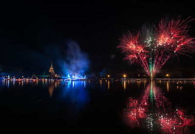 Firework display over river at night