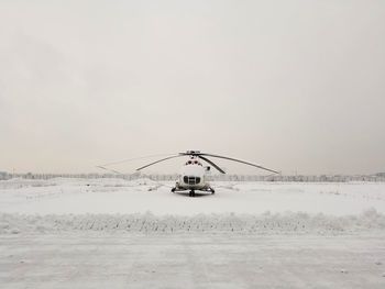 Ferris wheel on snow covered land against sky