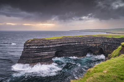 Fisherman standing on the edge of downpatrick head cliffs at dawn, ireland