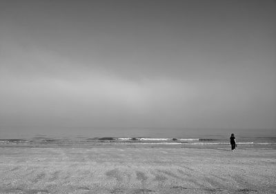 Rear view of woman walking at beach