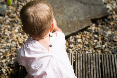 Rear view of boy crawling outdoors