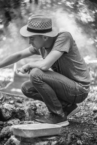 Midsection of man sitting on rock