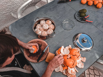 High angle view hands and oranges on table