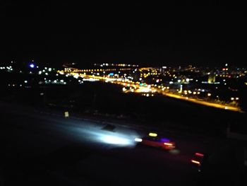 High angle view of illuminated city against sky at night