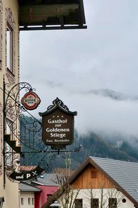 Information sign on building against sky in city