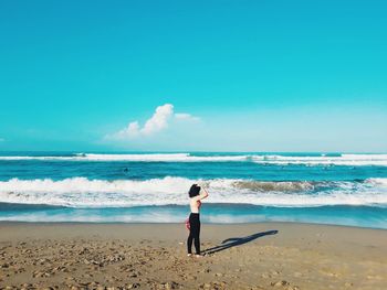 Full length of woman on beach against sky