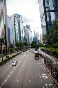 Cars on city street by buildings against sky