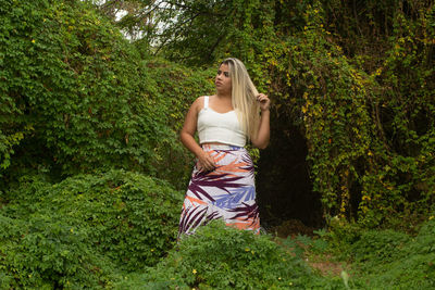 Woman standing by tree in forest