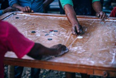 Cropped image of friends playing carrom