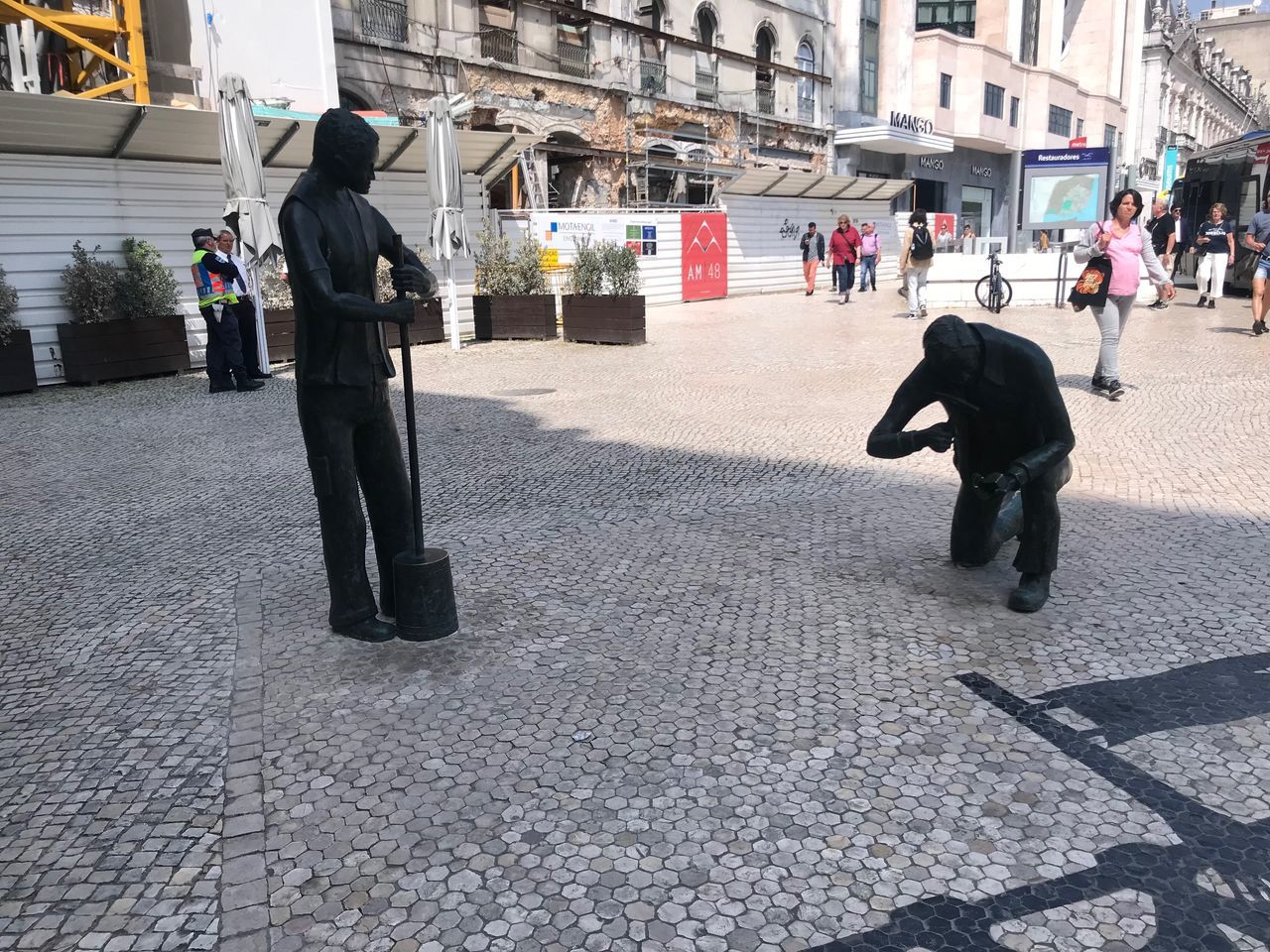 city, architecture, street, real people, building exterior, men, full length, built structure, people, group of people, city life, walking, incidental people, footpath, lifestyles, day, adult, transportation, rear view, women, outdoors, paving stone