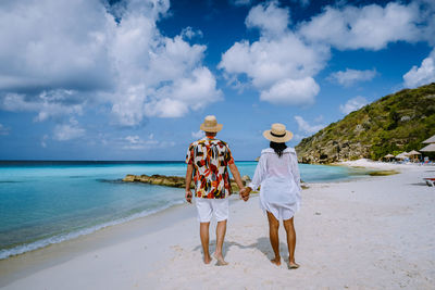 Women standing on beach against sky