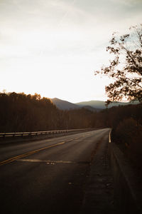 Empty road against sky during sunset