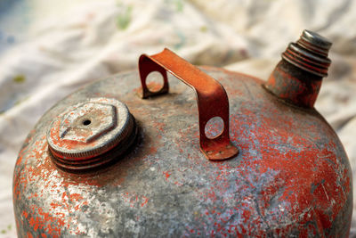 Vintage metal gasoline can with peeling red paint