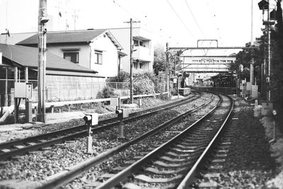 Railroad tracks amidst buildings against clear sky