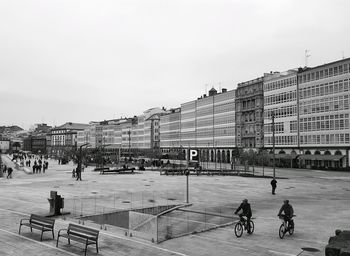 People on street against buildings in city