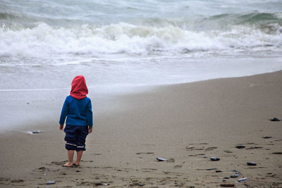 Rear view of boy walking on beach