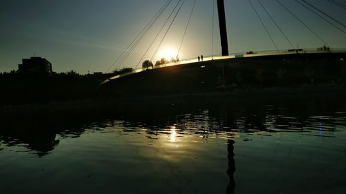 Bridge over river at sunset