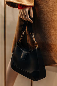 Classic black leather women's handbag with gold chain. fashion details