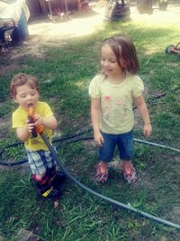 Siblings standing on field