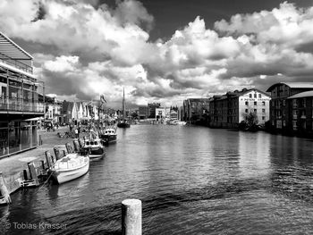 Boats moored in harbor against buildings in city